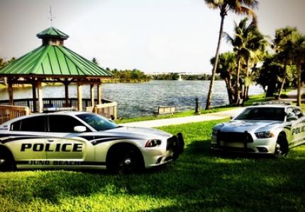 Juno Beach Police Cars parked on the grass in front of the waterfront and gazebo