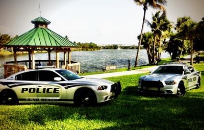 Juno Beach Police Cars parked on the grass in front of the waterfront and gazebo